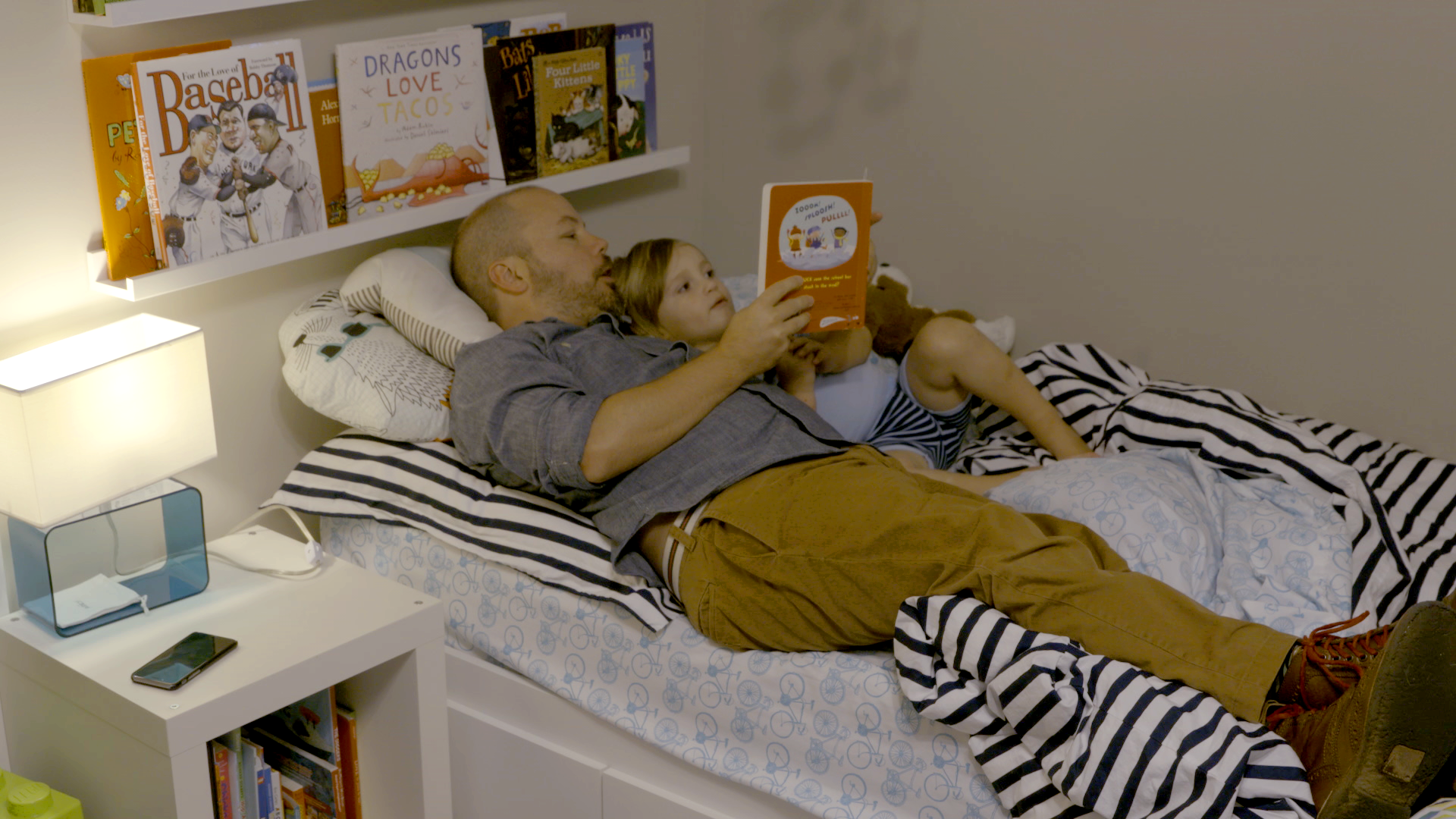 Adult reading to a child in bed
