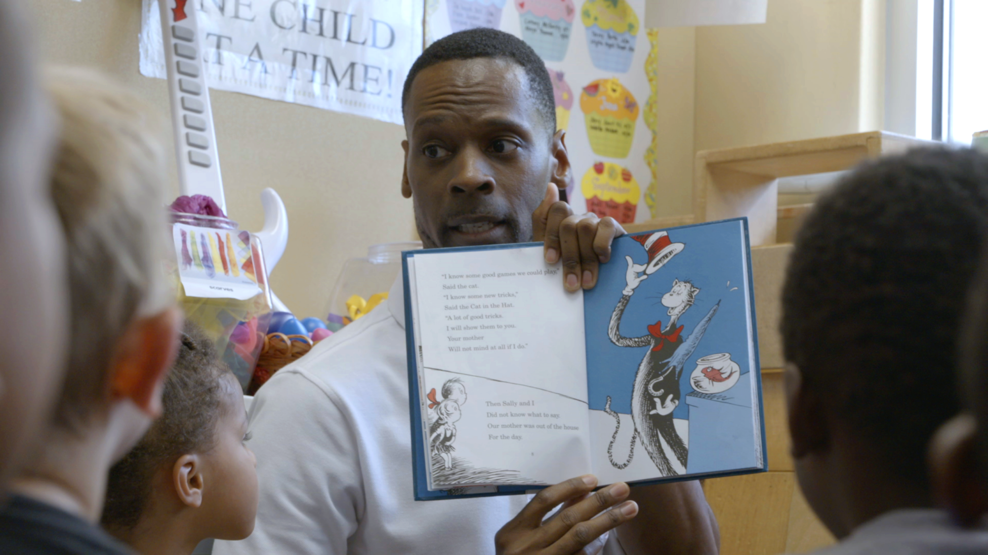 A man in a classroom reads 