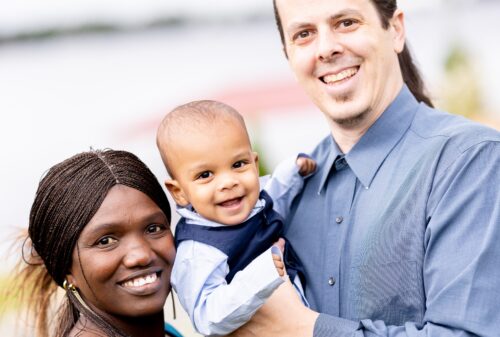 Maimouna holds up her baby in between her husband
