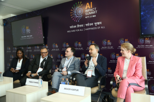 Five people present at panel discussion under sign reading 