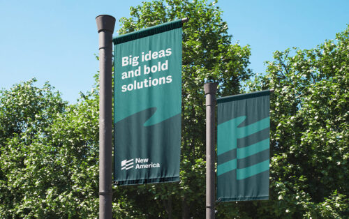 Two vertical banners with text and a wavy design, set against trees.