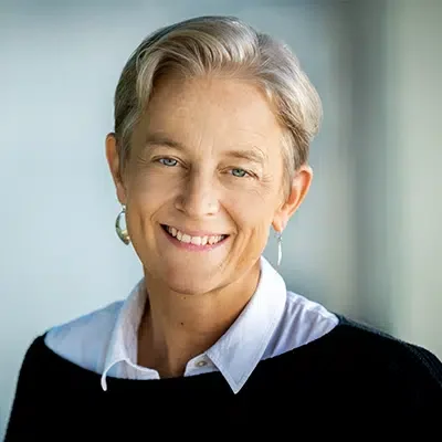 Head shot of Fernande Raine, short gray blonde with earrings