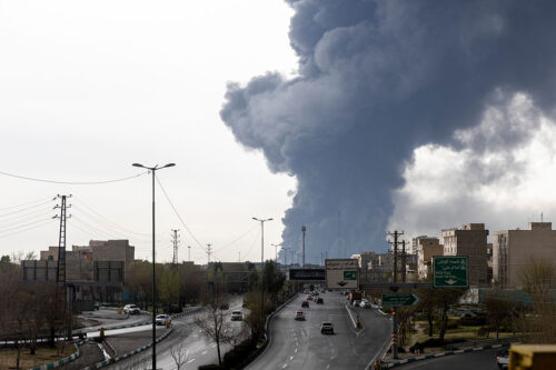 TEHRAN, IRAN - MARCH 8: Cars drive down a highway as smoke billows after overnight airstrikes on oil depots on March 8, 2026 in Tehran, Iran. The United States and Israel continued their joint attack on Iran that began on February 28. Iran retaliated by firing waves of missiles and drones at Israel, and targeting U.S. allies in the region. (Photo by Majid Saeedi/Getty Images)