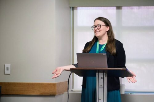 Allyson Cornett standing at a podium speaking