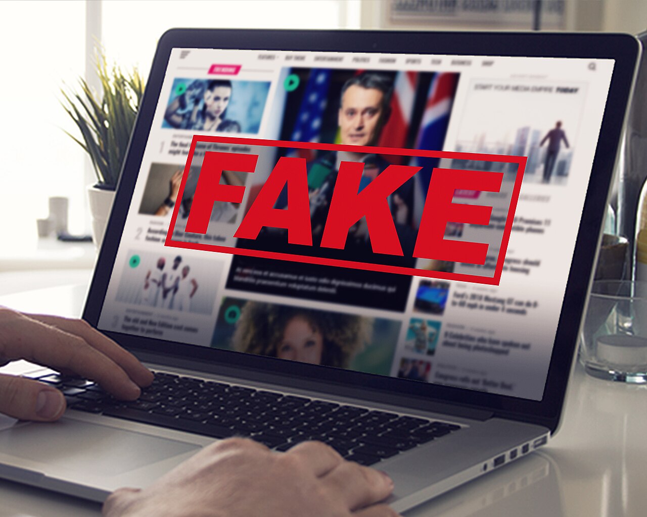 A close shot of a laptop with a news website pulled up, large red letters spell out 