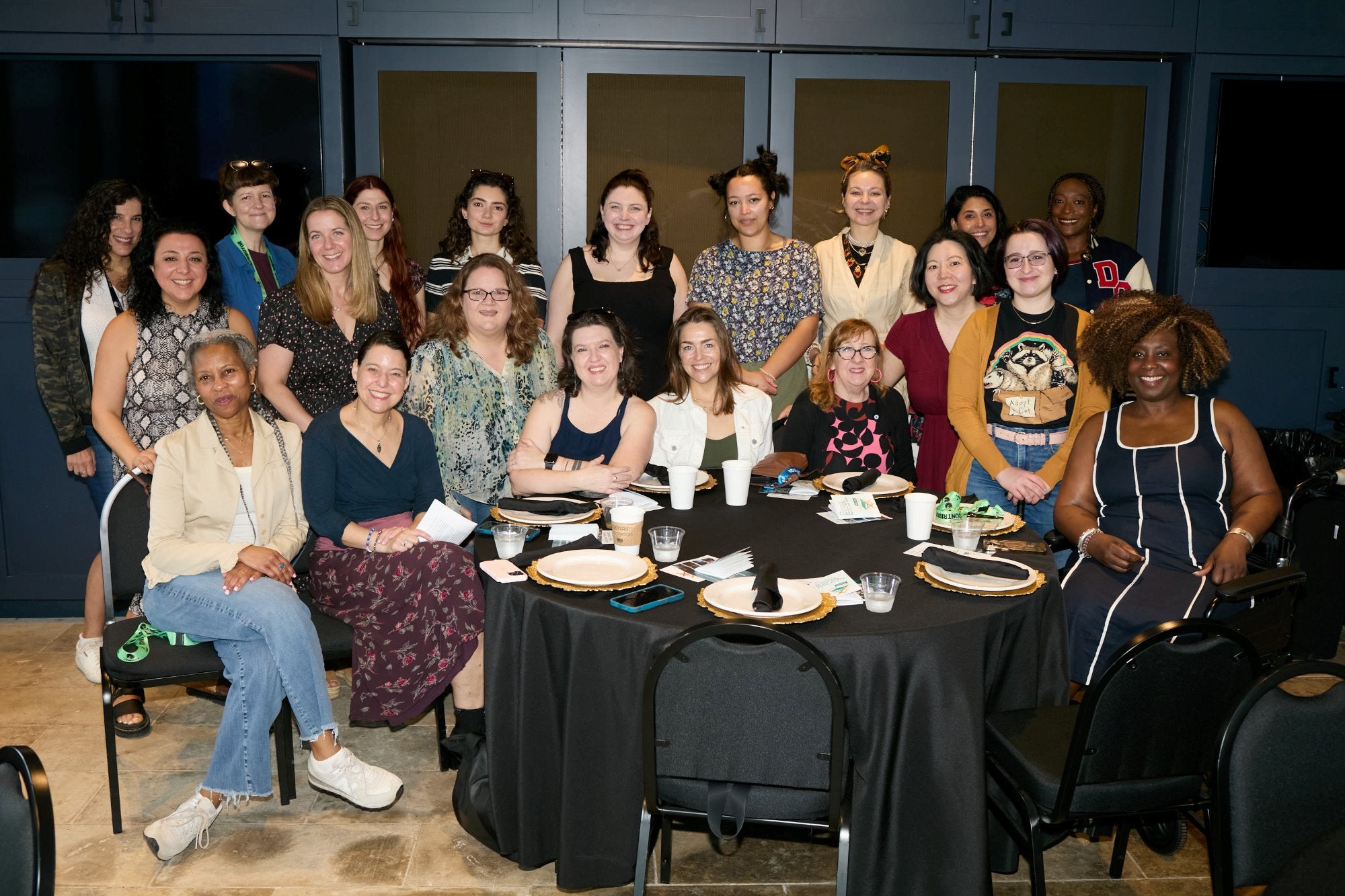 Members of Film Fatales gather in a group behind a round table set for brunch.