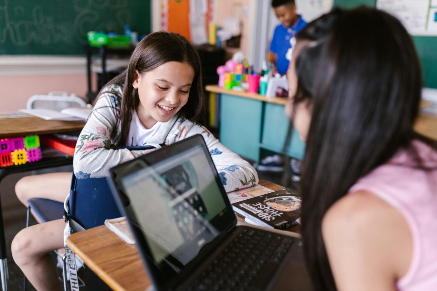 Two students working at a desk are pictured from above their heads.