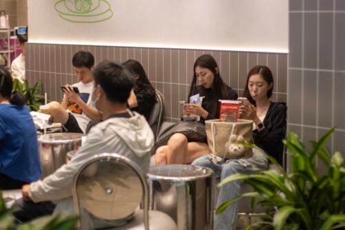 Image of people looking at their phones in Beijing, China.