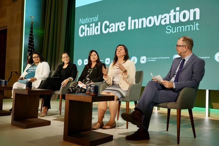 A panel of five professionals sitting on stage at the 