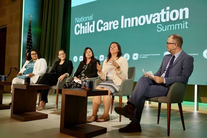 A panel of five professionals sitting on stage at the 