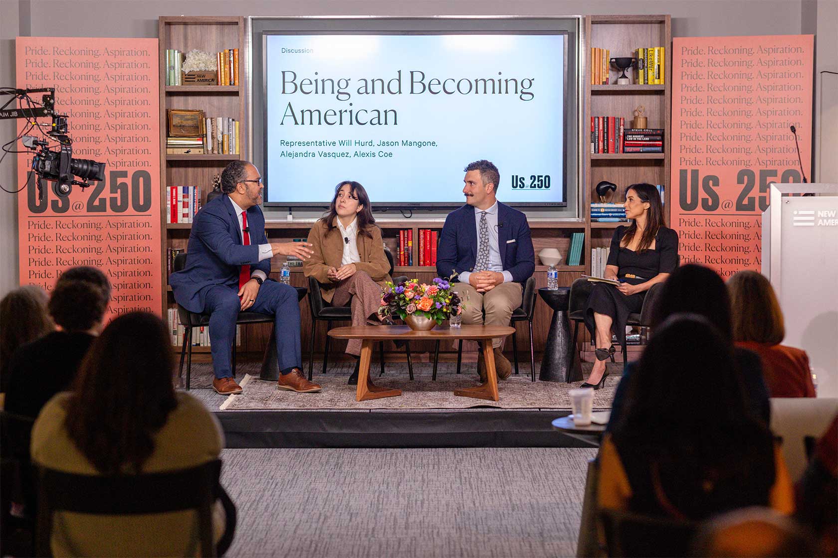 A panel discussion featuring four speakers on a stage about 