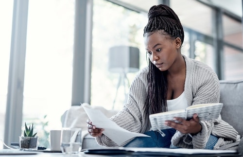 Black woman looking at a piece of paper sadly