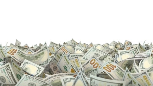 A pile of green dollar bills with white space above