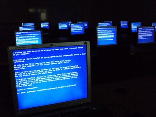 A sea of computer screens, each lit up by a blue error message.