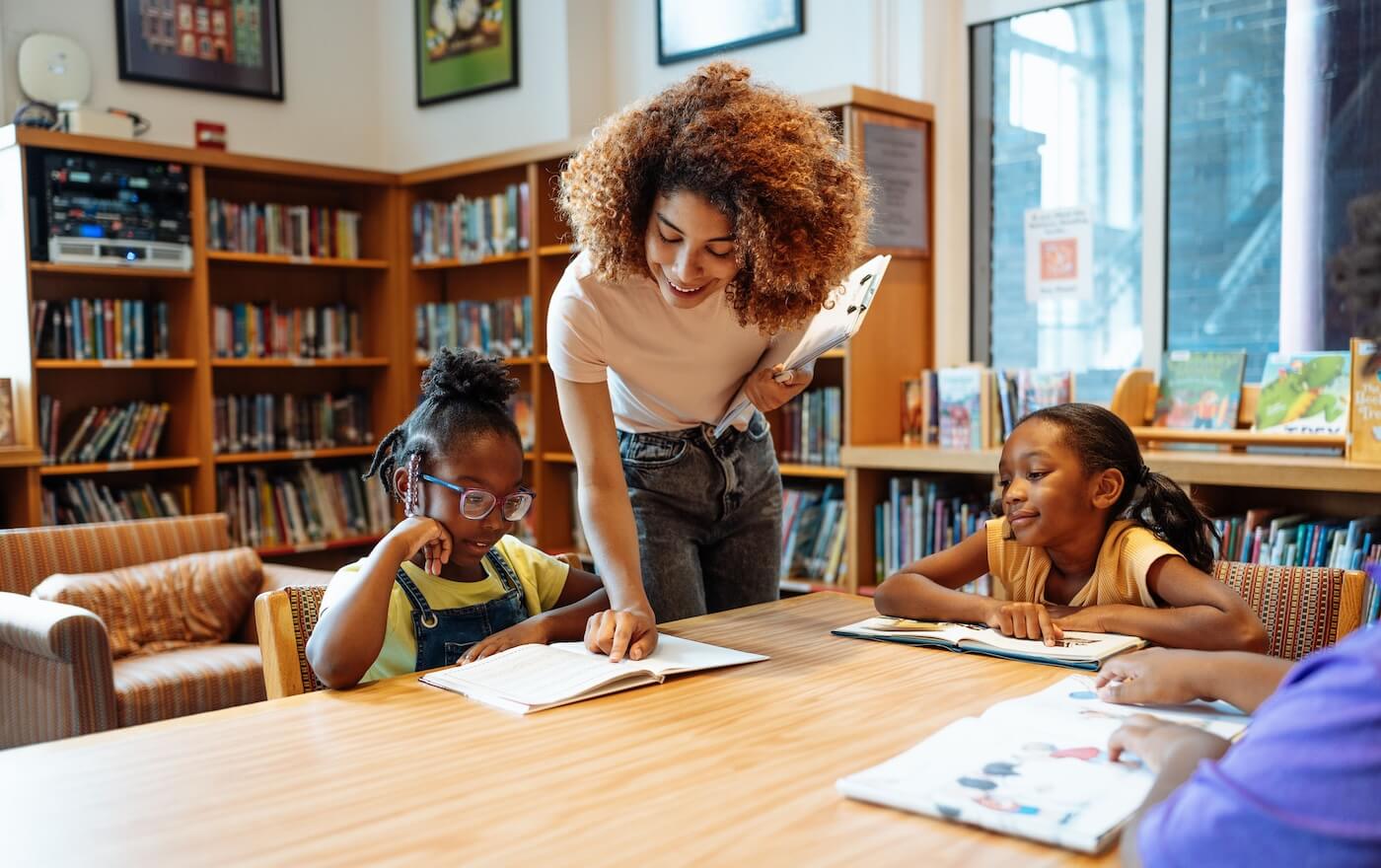 School children with teacher in library, having a reading and spelling class