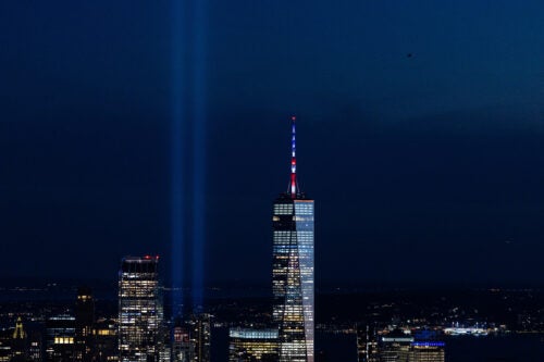 Skyline of New York City with the One World Trade Center and two beams of light honoring the twin towers that fell on 9/11.