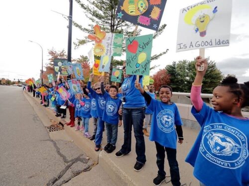 Young elementary-age students dressed in blue t-shirts reading 
