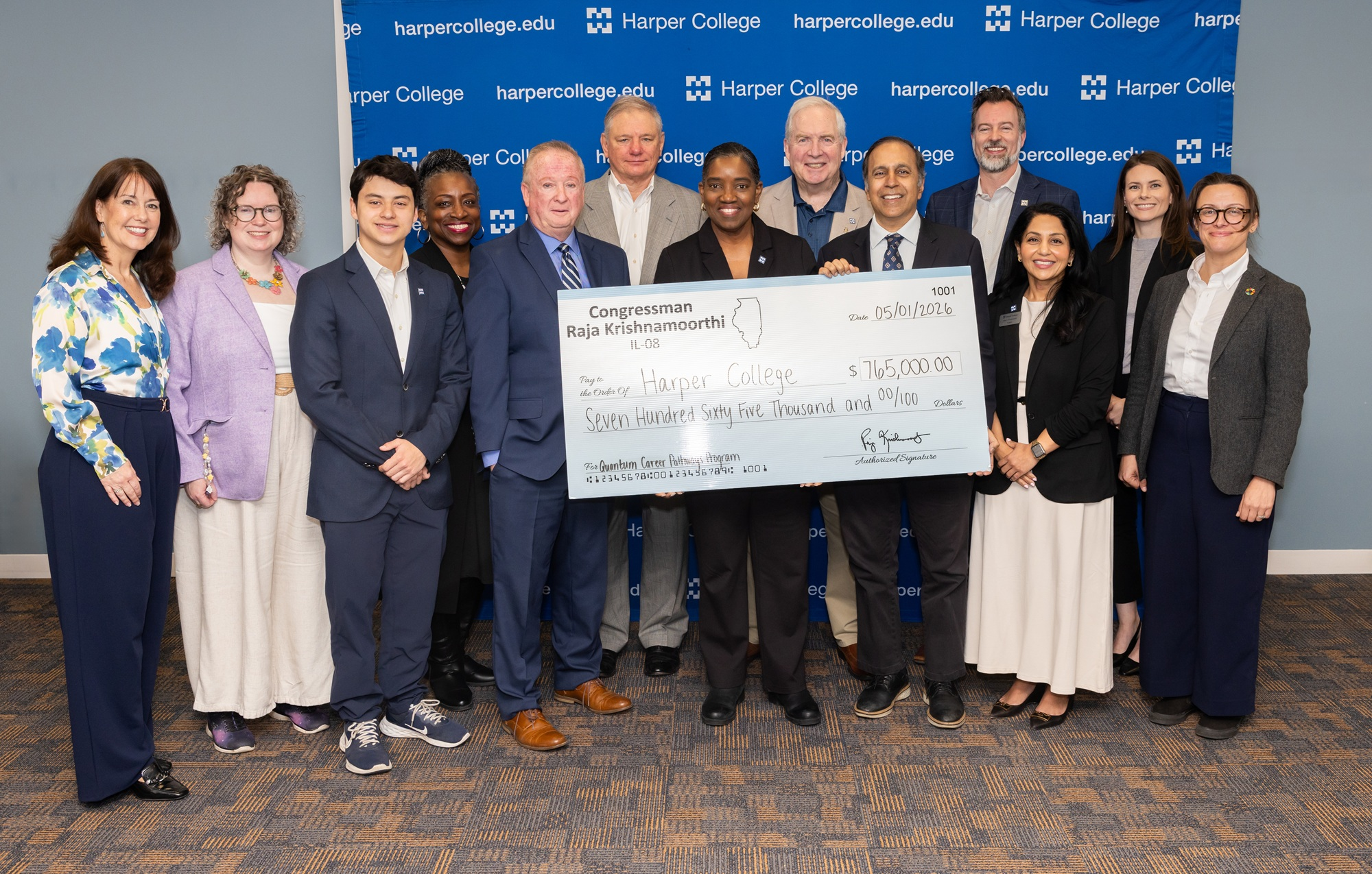 A group of people standing with a large check