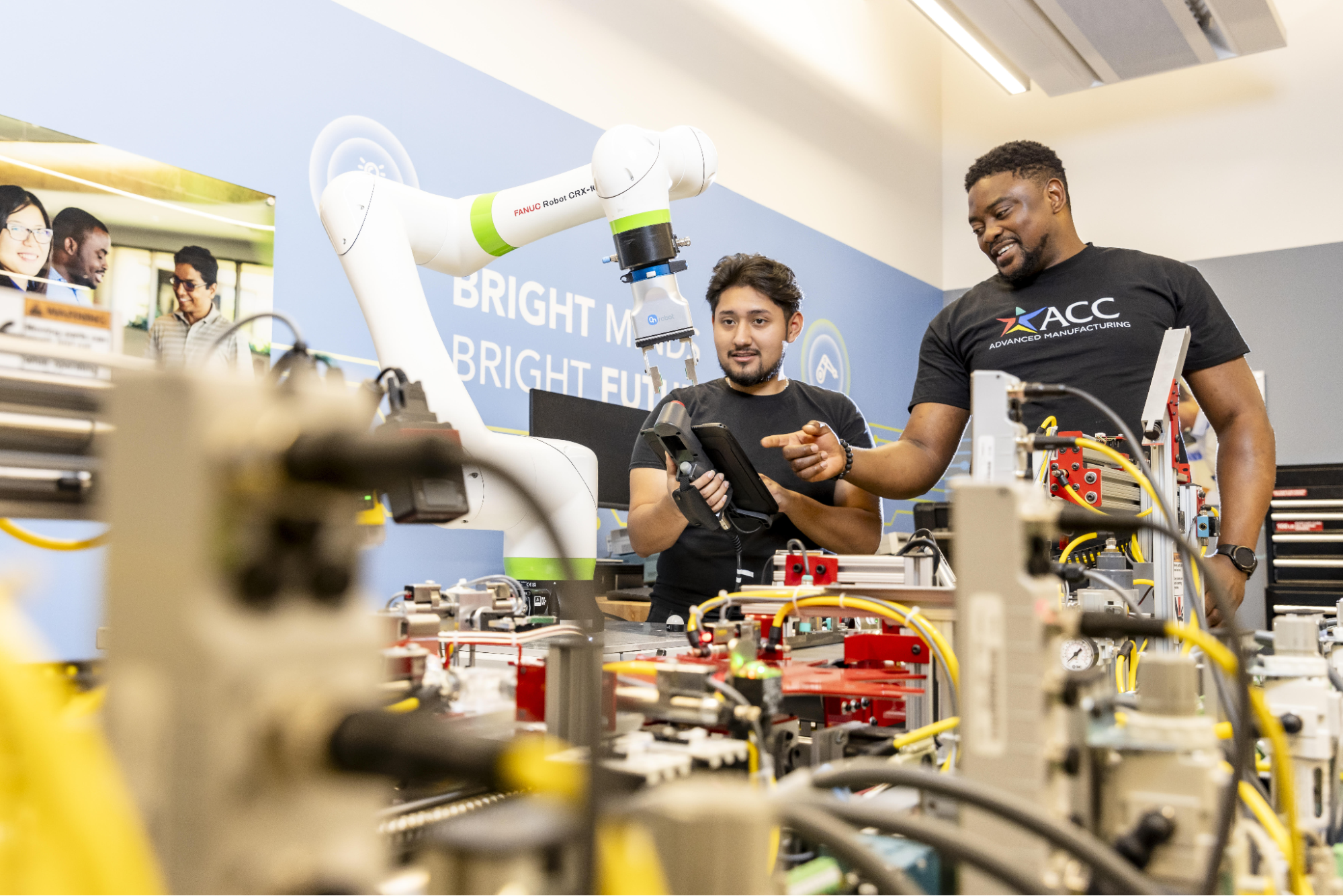 Two students controlling machinery with a remote