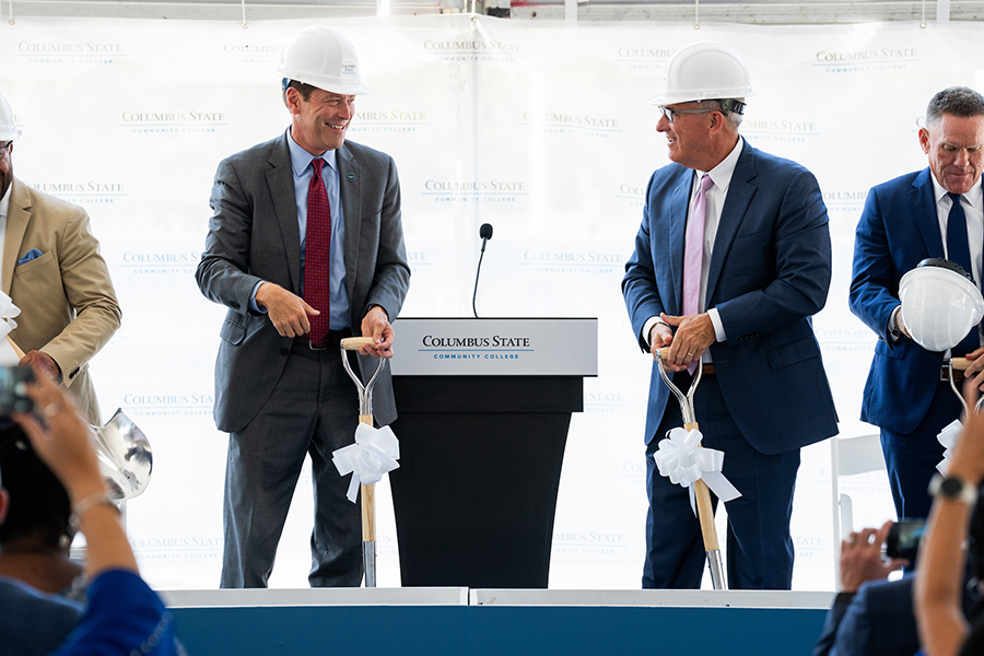 Two people holding shovels standing at a podium