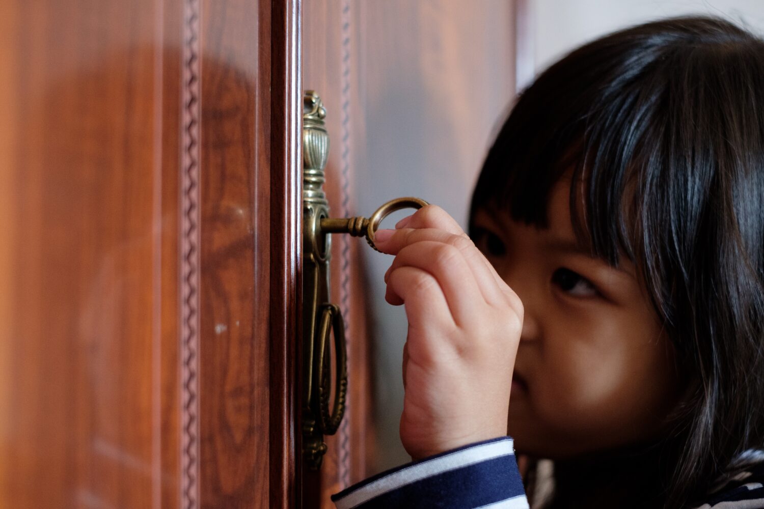 Child using key to unlock door
